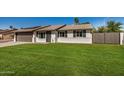 Charming single-story home with a well-manicured lawn and a two-car garage, complemented by solar panels at 1906 N Evergreen St, Chandler, AZ 85225