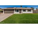 Charming single-story home with a well-manicured lawn and a two-car garage, complemented by solar panels at 1906 N Evergreen St, Chandler, AZ 85225
