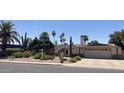 Charming single-story home featuring desert landscaping, an arched entryway, and a two-car garage at 2125 E Elmwood St, Mesa, AZ 85213