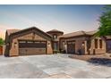 Beautiful single Gathering home with a three-car garage, neutral colored stucco, tile roof, and desert landscaping at 21284 E Camacho Rd, Queen Creek, AZ 85142
