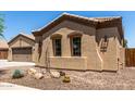 Close-up of house showing stucco, desert landscaping, and dual-pane windows at 21284 E Camacho Rd, Queen Creek, AZ 85142