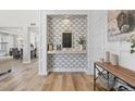 Inviting entryway with decorative wallpaper, a stylish mirror, and a wood-look console table, setting a warm and elegant tone at 2466 E Harrison Ct, Gilbert, AZ 85295