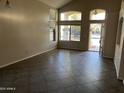 Open-concept living room with tile flooring and large windows for ample sunlight at 24919 W Illini St, Buckeye, AZ 85326