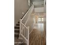 Bright, neutral colored entryway showing a carpeted staircase and wood look tile on the floor at 3390 S 180Th Ln, Goodyear, AZ 85338