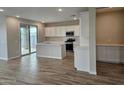Open concept kitchen with white cabinetry, stainless appliances, and wood look tile flooring at 3390 S 180Th Ln, Goodyear, AZ 85338
