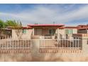View of the front of the home showing the entry, small porch, and white iron fence with brick at 3622 W Sunland Ave, Phoenix, AZ 85041