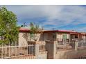 View of the exterior with a concrete driveway, brick and white iron fence, and the front porch at 3622 W Sunland Ave, Phoenix, AZ 85041