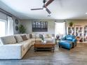 A cozy living room featuring a comfortable sectional sofa, a ceiling fan, and neutral décor at 37008 N Aleutian Dr, San Tan Valley, AZ 85143