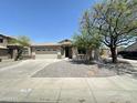 Charming single story home featuring a two-car garage, desert landscaping, and mature trees at 7419 S 45Th Ave, Laveen, AZ 85339