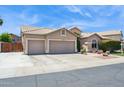 Spacious driveway leads to a three-car garage on this well-kept home under a sunny sky at 758 S Lagoon Dr, Gilbert, AZ 85233