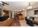 Bright living room flows into kitchen with stainless appliances, light colored cabinetry, and modern lighting fixtures at 7601 E Indian Bend Rd # 1040, Scottsdale, AZ 85250