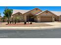 Inviting single-story home featuring desert landscaping, an attached garage and a neutral color palette at 9109 W Watson Ln, Peoria, AZ 85381
