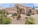 Beautiful home with desert landscaping, a two-car garage and an arched front entry at 9239 E Karen Dr, Scottsdale, AZ 85260
