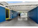 Spacious carport featuring block wall, yellow door, and a well-maintained concrete floor at 1029 E Palo Verde Dr, Phoenix, AZ 85014