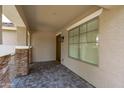 Welcoming covered front porch featuring elegant stone accents, tiled flooring, and a stylish front door at 12546 N 142Nd Ln, Surprise, AZ 85379