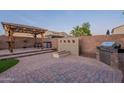 Inviting outdoor space with covered pergola, seating, built-in grill, and fire feature for entertaining at 13318 W Indianola Ave, Litchfield Park, AZ 85340