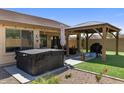 Beautiful backyard with a covered patio, hot tub, desert landscaping, and an inviting outdoor space at 1415 N Frederick Ln, Casa Grande, AZ 85122