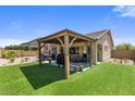 Lush backyard featuring a covered patio, well-maintained green lawn, and a private outdoor space at 1415 N Frederick Ln, Casa Grande, AZ 85122