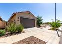 This single-level home features a two-car garage with desert landscaping and easy street access at 14233 W Georgia Dr, Surprise, AZ 85379