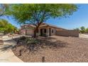 Exterior view of a tan single-story home with a two-car garage and desert landscaping at 16219 W Yucatan Dr, Surprise, AZ 85379