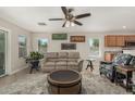 Bright living room with tile floors, a ceiling fan, a beige sofa, and windows for natural light at 16219 W Yucatan Dr, Surprise, AZ 85379