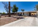 Attractive single-story home with gravel landscaping, mature trees, and covered parking at 1628 E Sunland Ave, Phoenix, AZ 85040