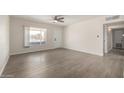 Spacious living area featuring wood-look floors, a ceiling fan, and ample natural light at 1628 E Sunland Ave, Phoenix, AZ 85040