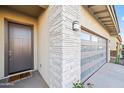A detailed view of the front entrance, highlighting the stone accents, modern garage door, and inviting entry of the home at 17706 N Rosa Dr, Maricopa, AZ 85138