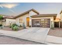 Attractive single-story home with desert landscaping, boasting a sleek garage door and neutral hues under a bright sky at 17706 N Rosa Dr, Maricopa, AZ 85138