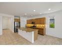 Modern kitchen features granite countertops, stainless steel appliances and tiled flooring at 18032 W Muirwood Dr, Goodyear, AZ 85338