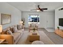 Bright living room featuring neutral tones, plush seating, ceiling fan, and a view to the outside at 2127 W Marco Polo Rd, Phoenix, AZ 85027