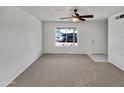 Inviting living room featuring neutral carpeting, a ceiling fan, and ample natural light from a front-facing window at 2127 W Marco Polo Rd, Phoenix, AZ 85027