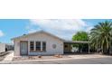 Charming single-story home featuring a covered carport, desert landscaping, and white siding at 2400 E Baseline Ave # 197, Apache Junction, AZ 85119