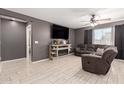Cozy living room with a fireplace, tile floors, a ceiling fan, and comfortable seating at 25539 W Gwen St, Buckeye, AZ 85326
