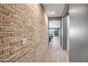 Hallway with a decorative brick wall detail leading to the bright living space at 26141 N 133Rd Ave, Peoria, AZ 85383