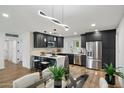 Modern kitchen with stainless steel appliances, black cabinets, and a marble island at 3707 E Amelia Ave, Phoenix, AZ 85018