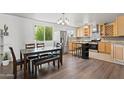 Bright kitchen and dining area featuring stainless steel appliances, wood cabinets, and a large window at 5802 N 61St Dr, Glendale, AZ 85301
