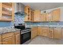 Stylish kitchen boasts stainless steel appliances, granite countertops, and custom backsplash at 5802 N 61St Dr, Glendale, AZ 85301