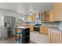 Open concept kitchen with stainless steel refrigerator, updated cabinets, granite countertops, and large island at 5802 N 61St Dr, Glendale, AZ 85301