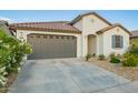 Charming single-Gathering home featuring a tile roof, desert landscaping, and attached two-car garage at 5897 N 195Th Dr, Litchfield Park, AZ 85340