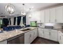 Beautiful kitchen with white cabinetry, granite countertops, stainless steel appliances and elegant pendant lighting at 5897 N 195Th Dr, Litchfield Park, AZ 85340
