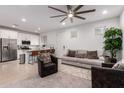 Inviting living area with hardwood floors, ceiling fan, kitchen access, and cozy seating, perfect for relaxation at 5897 N 195Th Dr, Litchfield Park, AZ 85340