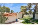 Home exterior featuring a gated entrance, arched gate, stucco wall, tile roof, and desert landscaping at 6147 E Lewis Ave, Scottsdale, AZ 85257