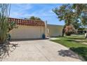 Charming home with a stucco wall, tile roof, paved driveway, and desert landscaping at 6147 E Lewis Ave, Scottsdale, AZ 85257
