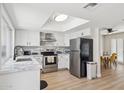 Bright kitchen with stainless steel appliances, white cabinets, and a skylight above a white quartz island at 6147 E Lewis Ave, Scottsdale, AZ 85257