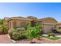 Landscaped front yard complements this home's two-car garage and tile roof, creating a welcoming curb appeal at 6620 S 16Th Dr, Phoenix, AZ 85041