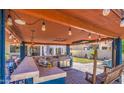 Stylish outdoor bar featuring a stainless steel grill, ample counter space, and a cozy swing bench at 838 E Nolan Pl, Chandler, AZ 85249
