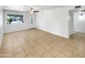 A bright living room featuring tile flooring, a ceiling fan, and window at 920 E Garnet Ave, Mesa, AZ 85204
