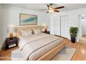 This main bedroom features a ceiling fan, natural light, and a large bed at 920 E Garnet Ave, Mesa, AZ 85204