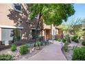 A well-maintained exterior featuring desert landscaping, creating an inviting outdoor space with a tree at 13300 E Via Linda Dr # 1058, Scottsdale, AZ 85259
